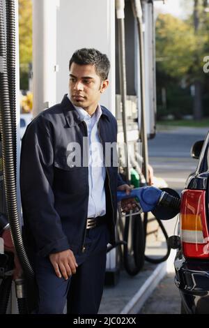 Junger Mann Pumpen gas Stockfoto