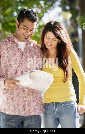 Junges Paar Prüfung Zeitung Stockfoto