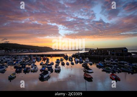 Lyme Regis, Dorset, Großbritannien. 9.. Juni 2022. Wetter in Großbritannien: Spektakulärer Sonnenaufgang über dem Cobb Harbour im Badeort Lyme Regis. Kredit: Celia McMahon/Alamy Live Nachrichten Stockfoto