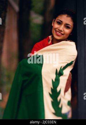 Junge Frau eingewickelt in einer Nationalflagge Stockfoto