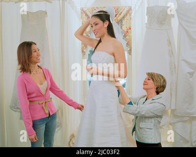Junge Braut ihr Kleid anprobieren Stockfoto