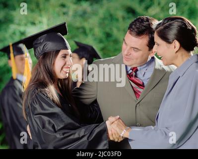 Mutter und Vater umarmt ihre graduate Tochter Stockfoto