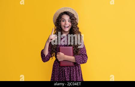 Inspiriert mit Idee Kind mit Frizz Haar halten Buch auf gelbem Hintergrund Stockfoto