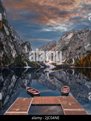 Pragser See, Italien - schöner Herbstaufgang am Pragser See in den italienischen Dolomiten bei Südtirol mit Holzbooten und Seekofel Mo Stockfoto