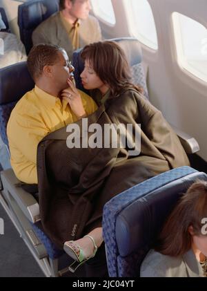 Älteres paar kuscheln in Flugzeug Stockfoto