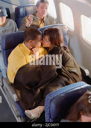 Älteres paar kuscheln in Flugzeug Stockfoto