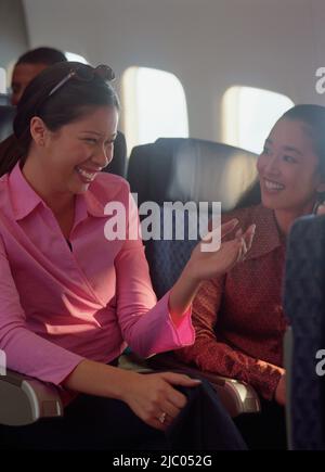 Junge Frauen reden am Flugzeug Stockfoto