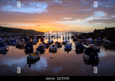 Lyme Regis, Dorset, Großbritannien. 9.. Juni 2022. Wetter in Großbritannien: Spektakulärer Sonnenaufgang über dem Cobb Harbour im Badeort Lyme Regis. Kredit: Celia McMahon/Alamy Live Nachrichten Stockfoto