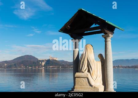 Statue und Schloss Rocca Borromea di Angera am Lago Maggiore in Angera, Lombardei, Italien. Stockfoto