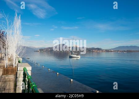 Segelboot und Schloss Rocca Borromea di Angeraon Lago Maggiore in Angera, Lombardei, Italien. Stockfoto