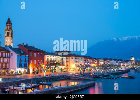 Dorf Ascona bei Nacht mit Berg- und Alpensee Maggiore im Tessin, Schweiz. Stockfoto