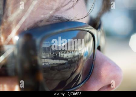 Hafen mit Booten reflektiert über eine Frau Sonnenbrille in Locarno, Schweiz. Stockfoto