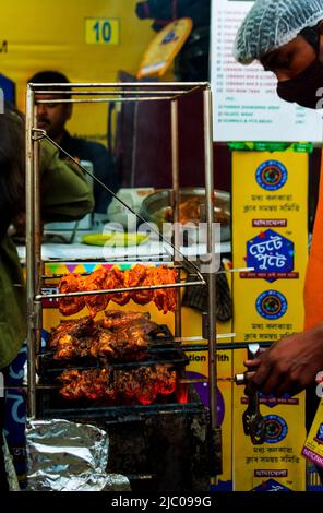 Kalkutta, Indien - 13. Februar 2022: Seitenansicht eines Mannes, der Hühnerkebabs in Flammen röstet. Diese Veranstaltung ist von einem Food Festival, wo die Menschen zu enjo versammeln Stockfoto