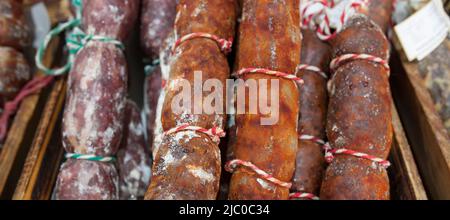 Rot-weißer iberischer Chorizo am Straßenmarktstand. Nahaufnahme Stockfoto