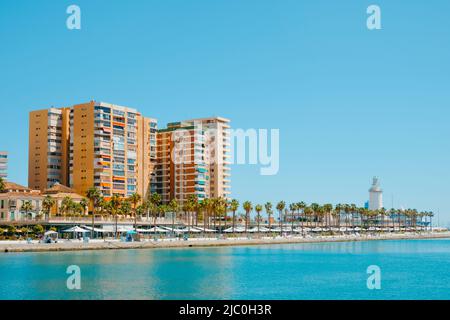 Malaga, Spanien - 26. Mai 2022: Blick über die Promenade Paseo del Muelle Uno in Malaga, Spanien, und den beliebten Leuchtturm La Farola auf der rechten Seite Stockfoto