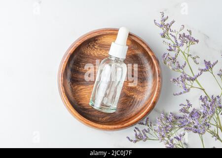 Draufsicht der Tropfflasche mit Hyaluronic-Kosmetikgel für feuchtigkeitsspendende Haut in Holzflasche. Draufsicht. Hautpflegekonzept. Paket ohne Branding. Stockfoto