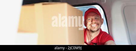 Mann genießt die Arbeit Putting Boxen in LKW für die weitere Lieferung an Adresse Stockfoto