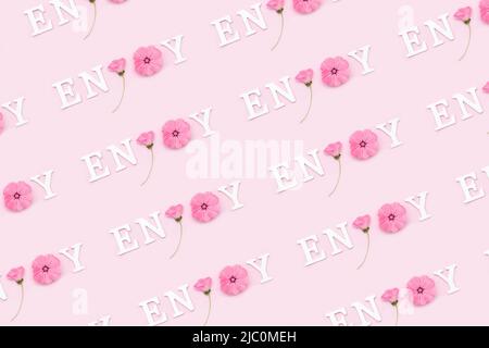 Viel Spaß. Kreatives inspirierendes Muster mit motivierenden Zitaten aus weißen Buchstaben und natürlichen Blumen auf rosa Hintergrund. Stockfoto
