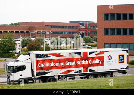 Ein Aldi-Lkw kehrt zum Hauptsitz und Lager von Aldi in Atherstone, England, Großbritannien, zurück. Der Hauptsitz von Aldi befindet sich seit 1990 in der Stadt. Die Hauptbüros sind hinter dem Fahrzeug zu sehen. BEACHTEN SIE DAS Bild, das von der öffentlichen Straße, nicht auf dem Aldi-Grundstück, aufgenommen wurde. Stockfoto