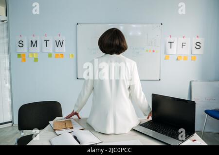 Geschäftsplanungsstrategie. Geschäftsfrau, Führungskraft, die im Büro vor dem Whiteboard des Diagramms steht und Notizen macht Stockfoto
