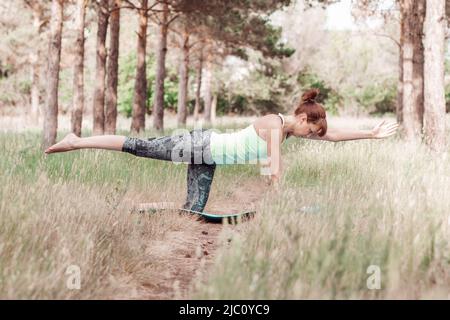 Junge schlanke Frau in Sportkleidung Yoga und Meditation in der Natur für Stressabbau und gesunden Geist zu üben Stockfoto