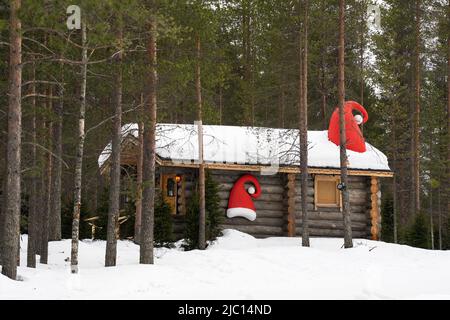 Santa's Village, Finnland - 20.. März 2022: Eine Holzhütte mit Santa-Hüten, in Santa's Village, Finnland. Stockfoto