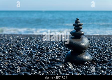 Ausgewogene Steine am schwarzen Strand Reynisfjara in Island Stockfoto