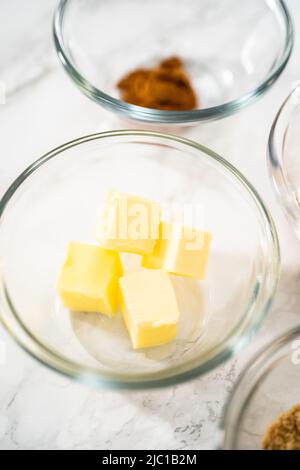 Gemessene Zutaten in Glasschüsseln zum Backen von Bananen-Haferflocken-Muffins. Stockfoto