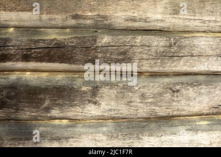 Struktur der Baumstämme in der Wand. Details des Hauses im Dorf. Die alte Oberfläche besteht aus Naturmaterial. Stockfoto