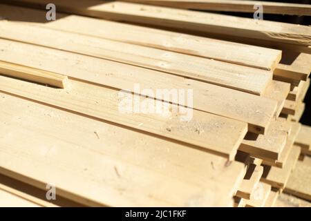 Platten auf Lager. Weiße Bretter liegen im Stapel. Baumaterial in der Schreinerei. Stockfoto