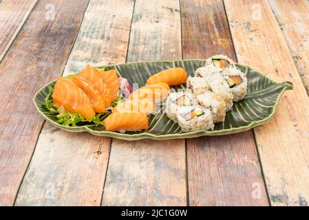 Gemischte Sushi-Platte mit norwegischem Lachs-Sashimi, Lachs-Nigiris und Uramaki mit Lachs und Avocado, Frischkäse, Nori-Algen und Sesamsamen Stockfoto