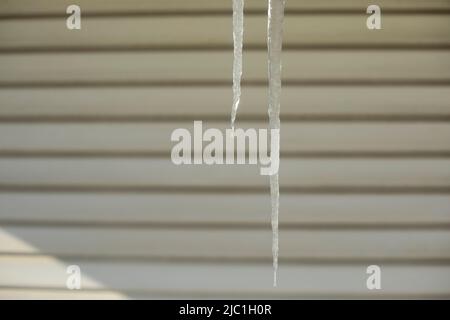 Eiszapfen hängen. Eis vor dem Hintergrund der Wand. Es war ein kalter Winter. Stockfoto