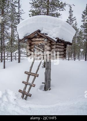 Holzhütte im Winter verschneiten Wald in Finnland, Lappland. Stockfoto