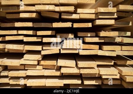 Platten auf Lager. Weiße Bretter liegen im Stapel. Baumaterial in der Schreinerei. Stockfoto