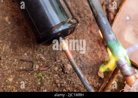 HLK-Techniker lötet einen Kupferrohranschluss für die Klimaanlage Stockfoto