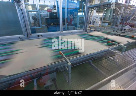 Nahaufnahme von kartografischen Industriemaschinen bei der Arbeit in einer Produktionslinie, Förderbänder sind sichtbar, keine Menschen sind anwesend. Stockfoto