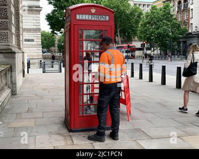 Whitehall, London, Großbritannien. 9.. Juni 2022. Eine Telefondose in Whitehall in der Nähe der Downing Street Nr. 10 wurde heute nach einer von der Polizei kontrollierten Explosion repariert, nachdem am Dienstag ein verdächtiges Paket in der Telefonbox hinterlassen wurde. Der Gegenstand wurde daraufhin als nicht risikobehaftet oder terrorisiert angesehen. Quelle: Maureen McLean/Alamy Live News Stockfoto