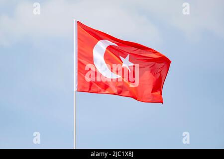 Türkische Nationalflagge winkt am blauen Himmel. Stockfoto