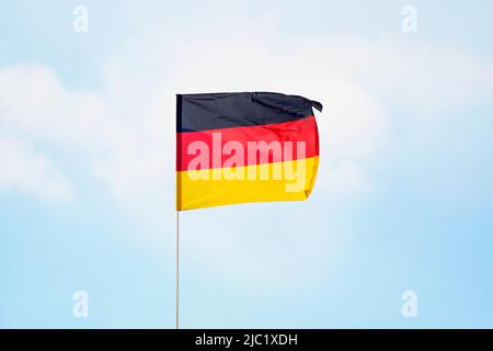 Deutschland Flagge auf bewölktem Himmel Hintergrund. Nahaufnahme wehende Flagge von Deutschland. Flaggensymbole von Deutschland. Stockfoto