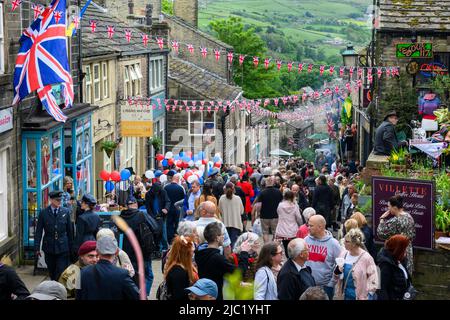 Haworth 1940er-Wochenende (geschäftige, überfüllte, malerische Hauptstraße, dekoriert in rot-weiß-blauen Union Jacks, beliebter Familientag) - West Yorkshire, England. Stockfoto