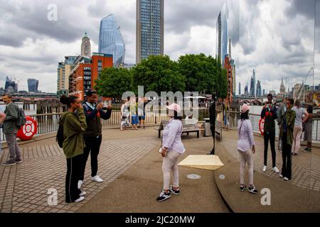 London, Großbritannien. 9.. Juni 2022. Menschen, die den Blick auf die City of London genießen, spiegeln sich in der neuen Ausstellung von Saint Laurent mit dem Titel Self 07 wider, die 6 Magnum-Fotografen mit Fotos in 6 Städten zeigt, kuratiert von Anthony Vaccarello. Kredit: Karl Black/Alamy Live Nachrichten Stockfoto