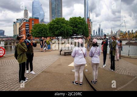 London, Großbritannien. 9.. Juni 2022. Menschen, die den Blick auf die City of London genießen, spiegeln sich in der neuen Ausstellung von Saint Laurent mit dem Titel Self 07 wider, die 6 Magnum-Fotografen mit Fotos in 6 Städten zeigt, kuratiert von Anthony Vaccarello. Kredit: Karl Black/Alamy Live Nachrichten Stockfoto