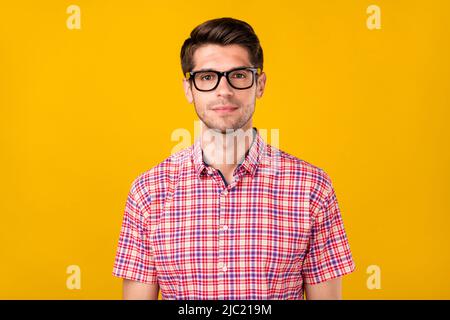 Foto von ruhigen friedlichen jungen Mann tragen Brille karierte Casual Shirt Arbeiter isoliert auf gelbem Hintergrund Stockfoto