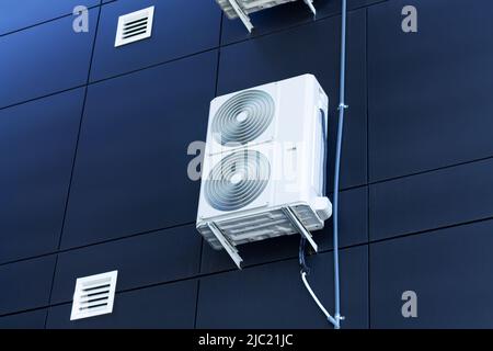 Die Kompressoreinheit der Klimaanlage sollte draußen an der Hauswand installiert werden Stockfoto