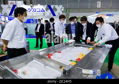 Tokio, Japan. 9.. Juni 2022. Während der Internationalen Ausstellung für Lebensmittelmaschinen und -Technologie (FOOMA JAPAN) im Tokyo Big Sight in Tokio sehen sich Besucher Gemüse auf einem Abscheider für Fremdstoffe an. Die jährliche Ausstellung stellt die neuesten Produkte und Dienstleistungen für die Lebensmittelverarbeitung in 8 Hallen vor. FOOMA JAPAN läuft vom 7. Bis 10. Juni. (Bild: © Rodrigo Reyes Marin/ZUMA Press Wire) Stockfoto