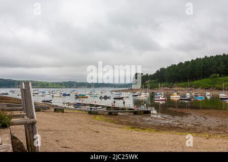 Ebbe in St. Just Creek, mit vielen verankerten Booten: St. Just in Roseland, Cornwall, Großbritannien Stockfoto