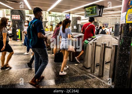 Passagiere, die an den Gates der automatischen Fare Collection am MRT-Bahnhof Orchard einchecken. Stockfoto