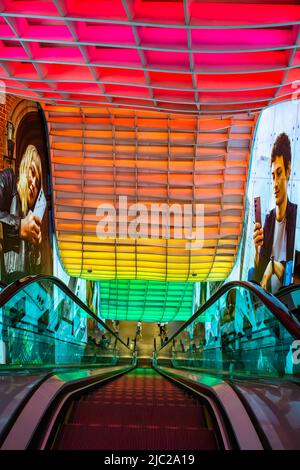 Erstaunliche Rolltreppe von Ion Orchard mit speziellen Lichteffekten und interessantem Wellendesign, um eine fantastische Aussicht beim Absteigen der Rolltreppe zu bieten. Stockfoto