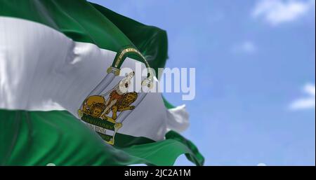 Andalusische Flagge winkt an einem klaren Tag im Wind. Andalusien ist die südlichste autonome Gemeinschaft auf der Halbinsel Spanien, die bevölkerungsreichste und die s Stockfoto