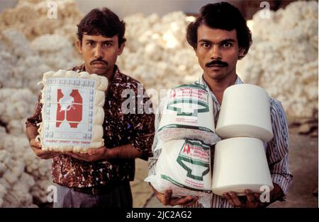 Bangladesch; zwei Arbeiter, die Baumwollfäden auf Spulen aus der Fabrik zeigen. Stockfoto